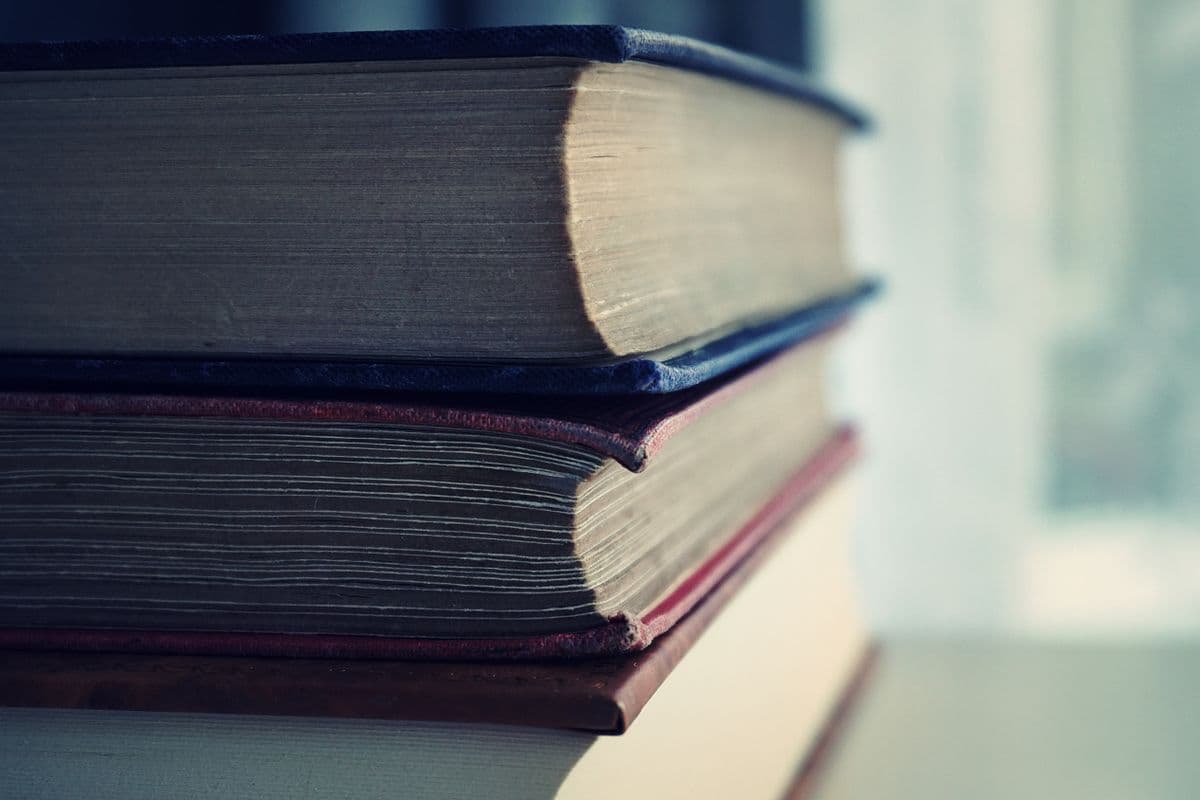 Books stacked beneath a lightbulb